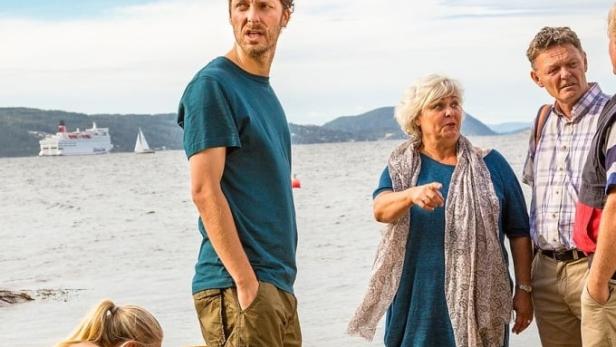 Das Filmplakat für „Neste Sommer“ zeigt eine Gruppe von Menschen am Strand.