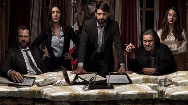 Das Filmplakat für „El Candidato“ zeigt eine Gruppe von Personen, die an einem Tisch voller Drogen sitzen.