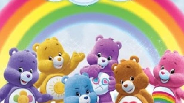 Eine Gruppe von Care Bears steht vor einem Regenbogen und einer Wolke mit der Aufschrift „Welcome to Care-a-Lot“.