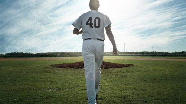 Ein Baseballspieler mit der Nummer 40 geht auf einem Feld in Richtung des hellen Himmels.