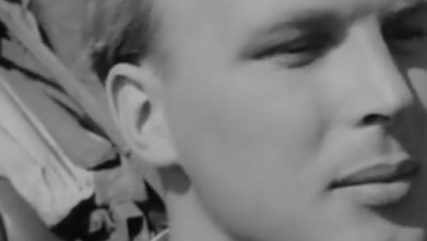 Ein Schwarzweißporträt eines jungen Mannes mit blondem Haar.