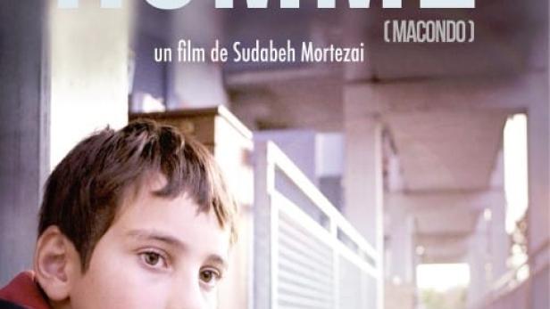 Das Filmplakat für „Le Petit Homme“ zeigt einen Jungen vor einem Gebäude.