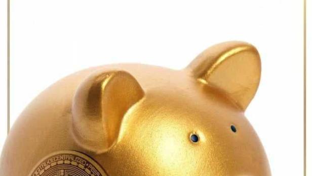 Ein goldenes Sparschwein mit einem Bitcoin-Symbol auf der Seite.
