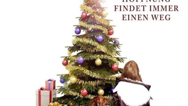 Ein Mädchen und ein Hund stehen vor einem Weihnachtsbaum mit Geschenken.