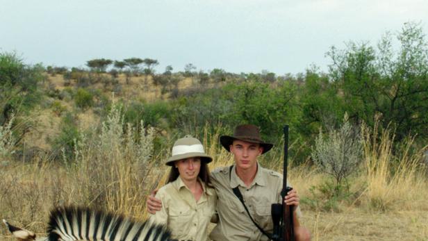 Das Filmplakat zu „Safari“ zeigt ein Paar mit Gewehr vor einem erlegten Zebra.