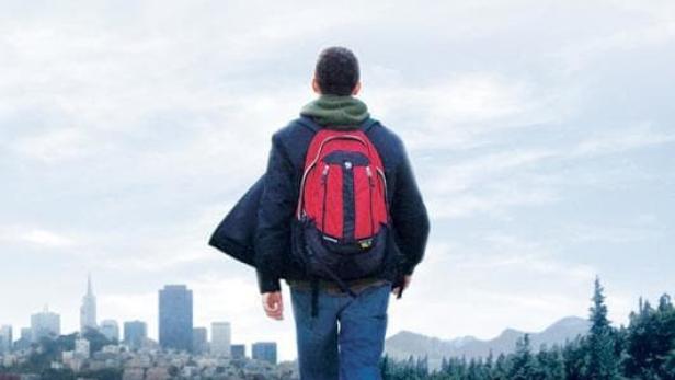 Ein Mann mit Rucksack geht auf einer Craigslist-Seite in Richtung der Skyline von San Francisco.