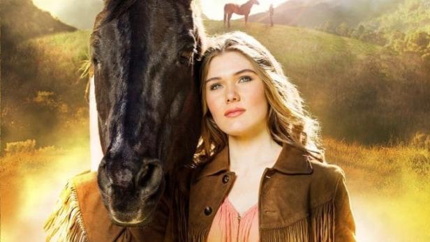 Das Filmplakat für „Ungezähmte Herzen“ zeigt eine Frau mit einem Mustang.