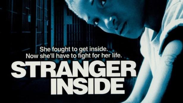Das Filmplakat für „Stranger Inside“ zeigt eine junge Frau vor einem Gefängnishintergrund.