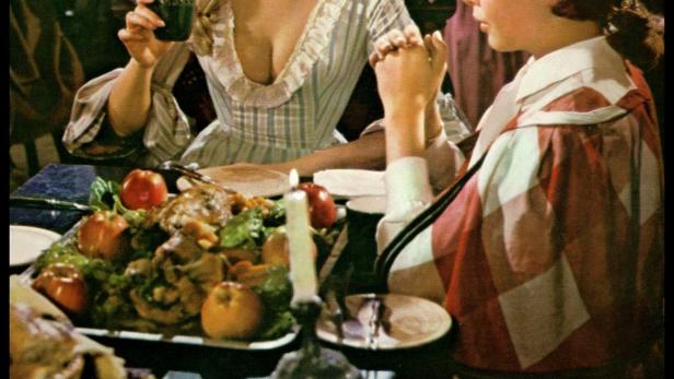Szene aus dem Film „Hilfe, mich liebt eine Jungfrau“ mit zwei Personen am Esstisch.