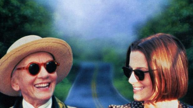 Das Filmplakat für „Camilla“ zeigt zwei Frauen, die in einem roten Cabriolet eine Landstraße entlangfahren.