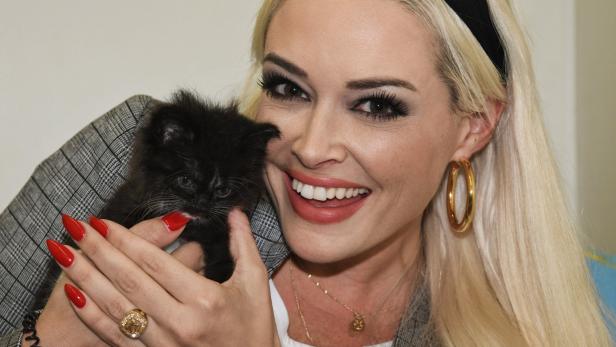 Blonde Frau posiert mit schwarzer Babykatze