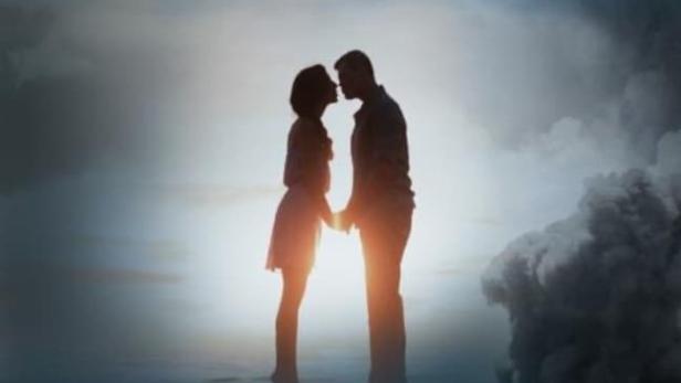 Ein Filmposter für „The Promise“ zeigt ein Paar vor dem Hintergrund von Flugzeugen und Rauch.