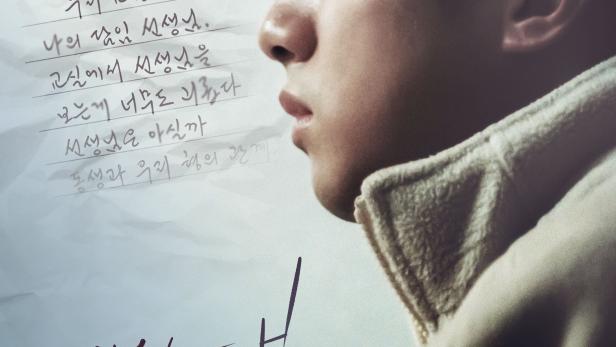 Ein junger Mann auf dem Filmplakat zu „Cannonball“ vor einem beschriebenen Blatt Papier.