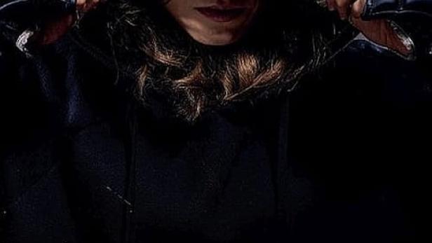 Eine Frau mit Kapuze und Handschuhen, im Vordergrund der rote Schriftzug „Furia“.