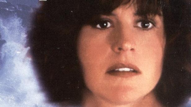 Das Filmplakat für „The Haunting of Seacliff Inn“ zeigt eine Frau vor einem unheimlichen Haus am Meer.