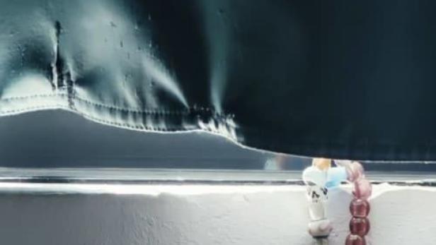 Das Filmplakat für „Auf Anfang“ zeigt eine Perlenkette vor einem dunklen Hintergrund.