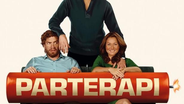 Das Filmplakat für „Parterapi“ zeigt Nikolaj Lie Kaas, Sidse Babett Knudsen und Søren Pilmark auf einer Couch hinter einer großen Dynamitstange.