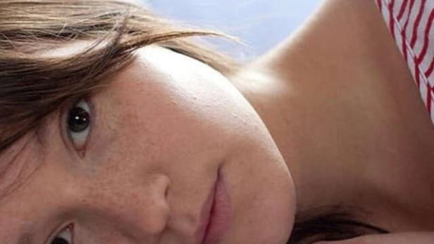 Das Filmplakat für „Pauline“ zeigt ein junges Mädchen, das auf einem Bett liegt.