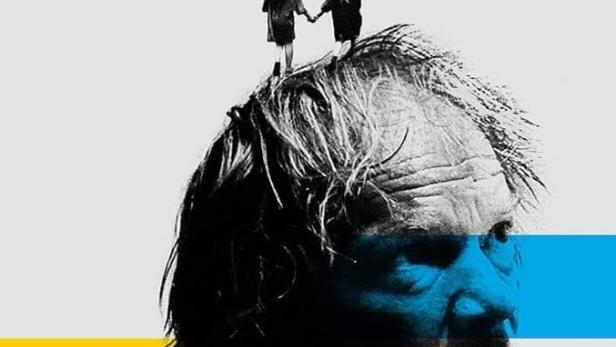 Das Filmplakat für „Tata“ zeigt ein Porträt von Eryk Lubos mit zwei kleinen Mädchen auf seinem Kopf.