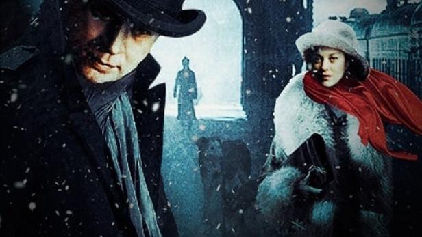 Ein Mann mit Zylinder und eine Frau mit rotem Schal im verschneiten Dezember.