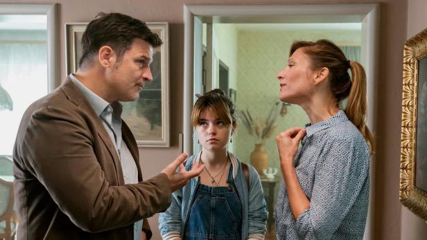 Ein Mann und eine Frau scheinen sich zu streiten, während ein Teenager zwischen ihnen steht.