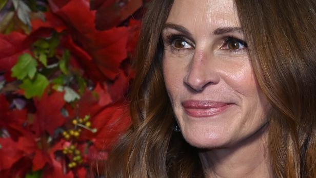 Nahaufnahme von Julia Roberts vor einem Hintergrund aus roten Blumen.