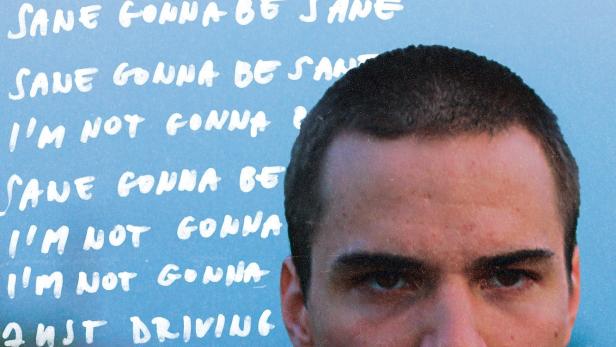 Das Filmplakat für „Larry“ zeigt das Gesicht eines jungen Mannes vor blauem Hintergrund mit Text.