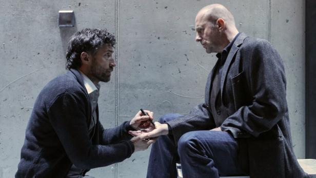 Ein Mann schreibt einem anderen mit einem Stift auf die Hand.