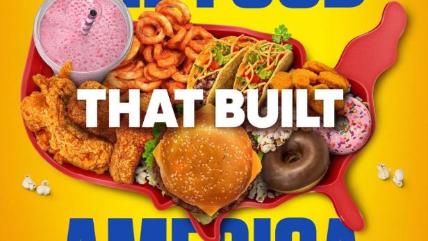 Ein Teller in Form der USA gefüllt mit Burgern, Tacos, Donuts und anderen amerikanischen Speisen.