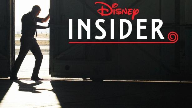 Ein Mann öffnet ein großes Tor vor dem Logo von „Disney Insider“.