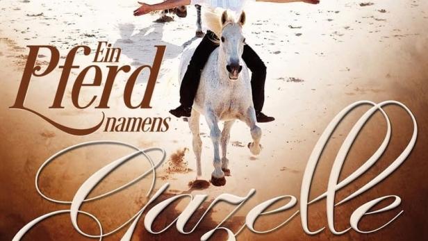 Ein Mann reitet auf einem weißen Pferd am Strand, im Hintergrund ein weiteres Pferd. Titelbild für „Ein Pferd namens Gazelle“.