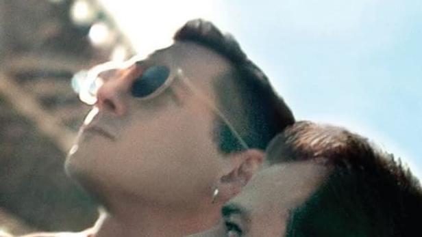 Das Filmplakat für „Almost Love“ zeigt zwei Männer, die in den Himmel schauen.