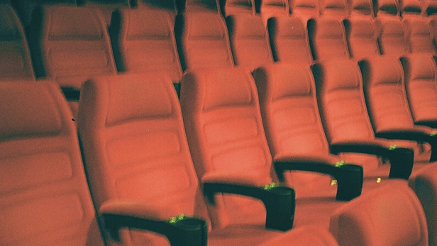 Leere rote Sitze in einem Kinosaal.