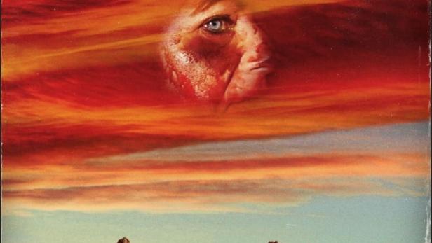 Das Cover des Films „The Outwaters“ zeigt eine Frau, die in einer Wüstenlandschaft läuft, über der ein Gesicht im Himmel erscheint.