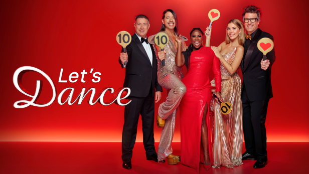 Fünf Juroren von „Let's Dance“ halten Wertungstafeln vor einem roten Hintergrund.