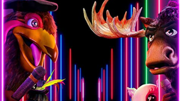 Figuren aus der Show „The Masked Singer“ vor einem Hintergrund mit Neonröhren.