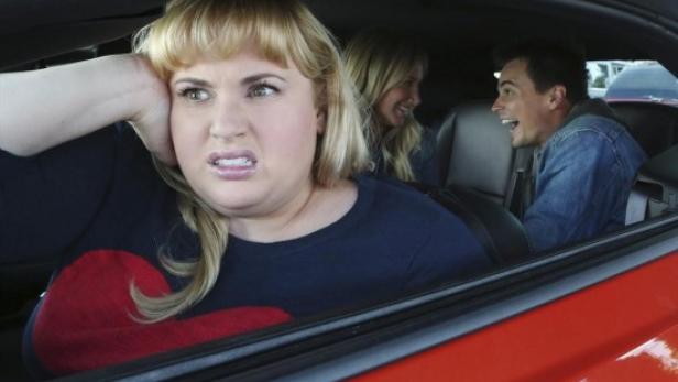 Rebel Wilson scheint in einem roten Auto von den Mitfahrern genervt zu sein.