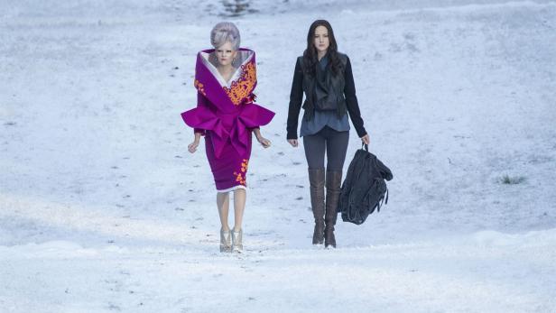 Effie Trinket und Katniss Everdeen in einer verschneiten Landschaft.