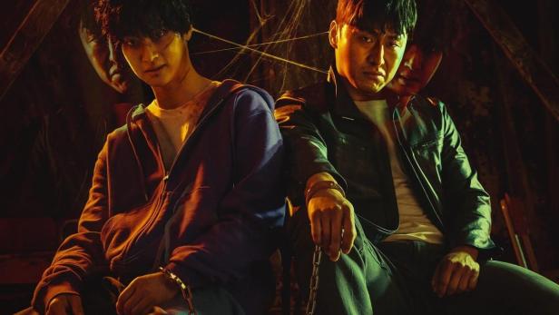 Das Filmplakat für den koreanischen Action-Thriller „Devils“ zeigt zwei Männer, die aneinandergekettet sind.