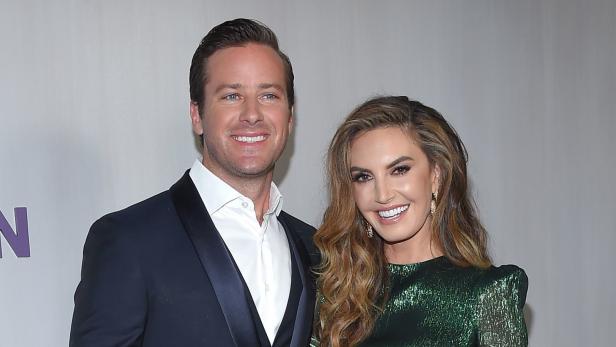 Armie Hammer und Elizabeth Chambers posieren lächelnd für ein Foto.