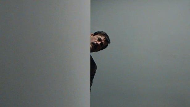 Ein Mann späht um die Ecke eines Büros mit der Aufschrift „Corner Office“.