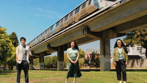 Das Filmplakat für „Shortcomings“ zeigt drei junge Menschen vor einer Hochbahn.
