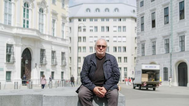 Kurt Langbein sitzt auf dem Ballhausplatz in Wien.