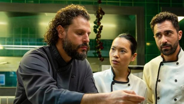 Drei Köche stehen in einer Hotelküche in Barcelona.