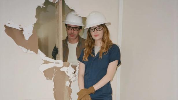 Emma Stone und Nathan Fielder stehen vor einem Loch in einer Wand.