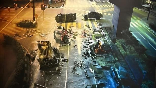 Ein zerstörtes Stadtbild mit umgestürzten Autos und Trümmern, möglicherweise nach einem Anschlag in Kuala Lumpur.