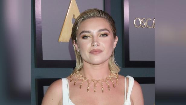 Florence Pugh mit blonden Haaren und goldenem Schmuck bei einer Oscar-Veranstaltung.
