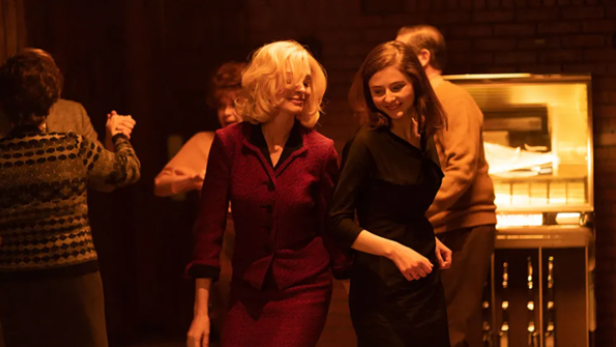 Anne Hathaway und Thomasin McKenzie tanzend in "Eileen"