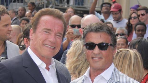 Früher Feinde, jetzt Freunde: Arnold Schwarzenegger (l.) und Sylvester Stallone. Arnold Schwarzenegger und Sylvester Stallone lächeln zusammen auf dem roten Teppich.