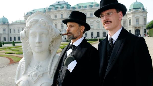 Viggo Mortensen und Michael Fassbender stehen in schwarzen Anzügen im Garten vom Schloss Belvedere